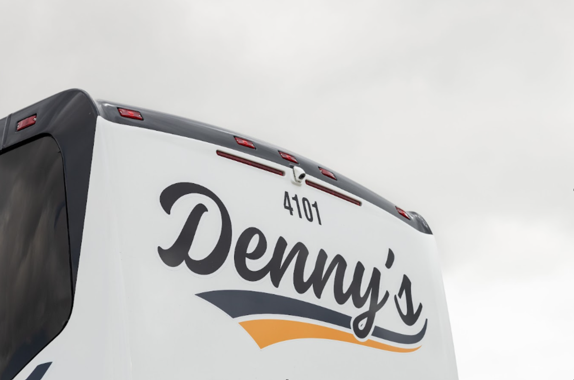 Professional Denny's Bus Lines charter bus traveling safely in Ontario