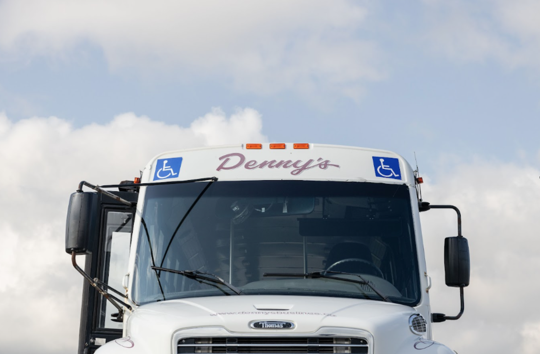 Denny’s Bus Lines charter bus on the road for safe group transportation