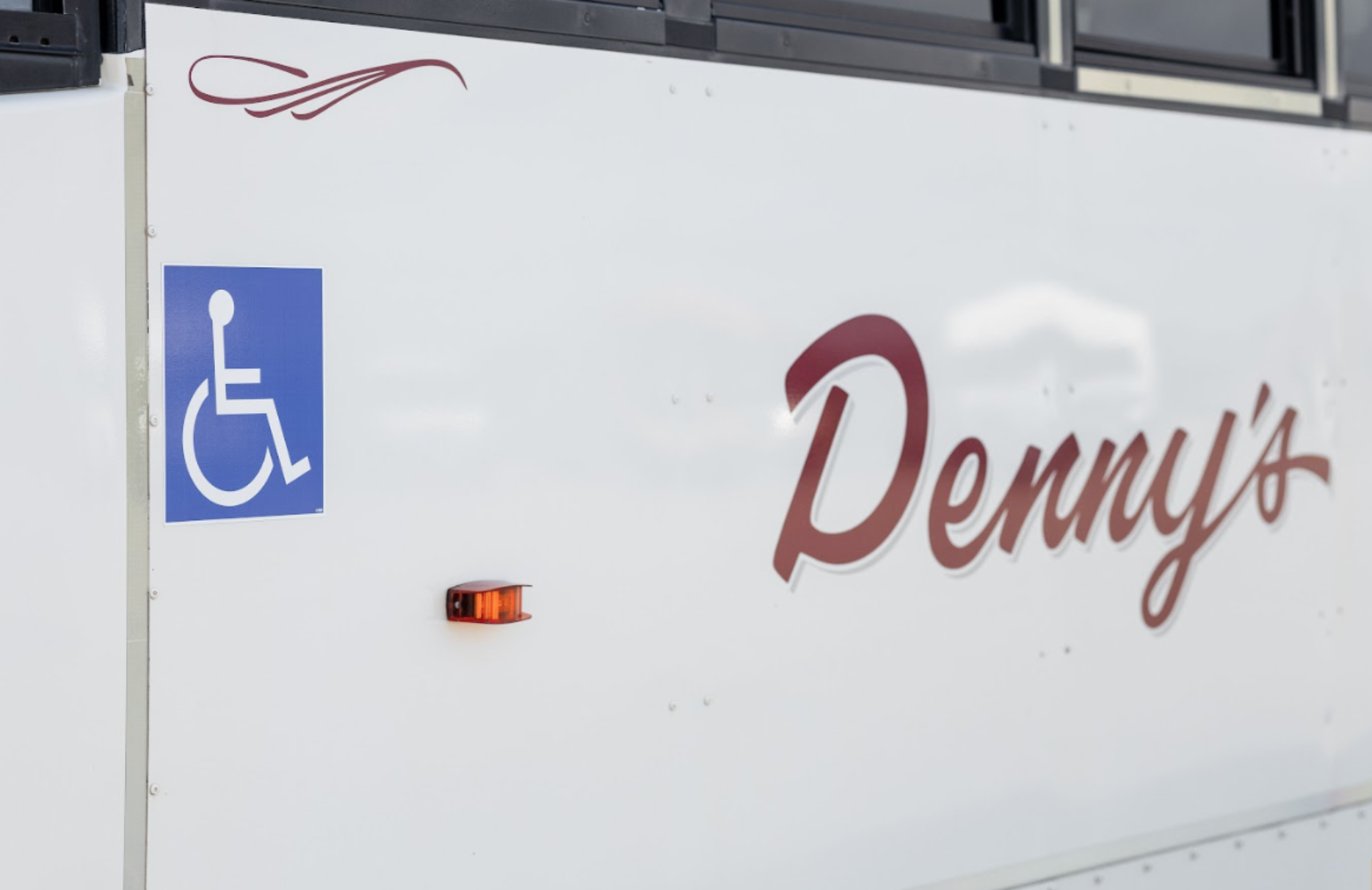Accessible Denny’s Bus Lines coach with wheelchair available for passenger boarding
